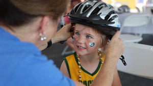 Young girl getting fitted with a new bike helmet from Bellin Health