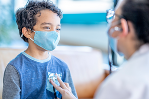 Boy wearing mask seeing doctor