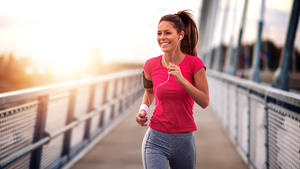 Young woman jogging outdoors on bridge