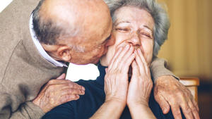 Senior man kissing senior woman on cheek