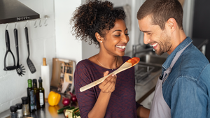 Couple tasting food with wooden spoon