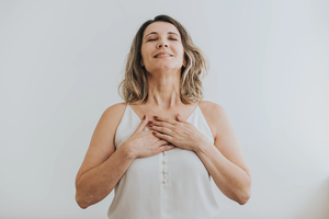 Portrait of a mature woman breathing with her hands on her chest
