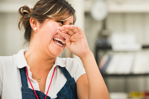 Female worker laughing in manufacturing plant