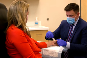 Dr. Derek Vaughn examines patient's hand