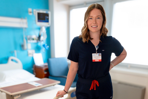 female nurse leaning on hospital bed